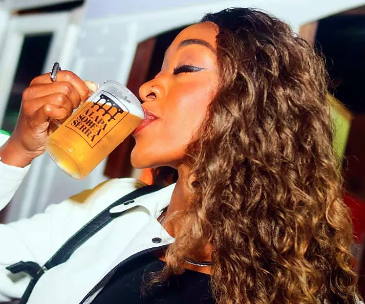 Mulher bebendo chope em caneca do festival